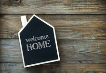 House Shaped Chalkboard Sign On Rustic Wood WELCOME HOME