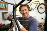 Fototapeta  - Man in workshop fixing bike frame