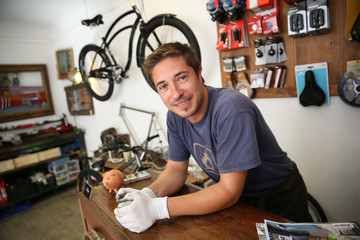 Portrait of smiling man working in bike rental shop