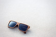 wooden sunglasses lying on the sand