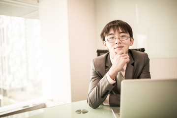 Wall Mural - Young handsome man using laptop in his office