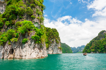 Wall Mural - beautiful scene of boat on green clear water with rock mountain