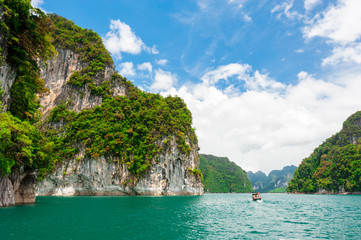 Wall Mural - beautiful scene of boat on green clear water with rock mountain