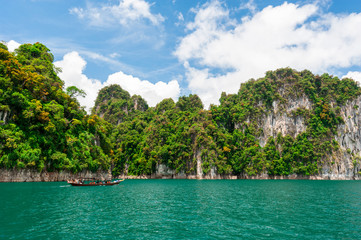 Wall Mural - beautiful scene of boat on green clear water with rock mountain