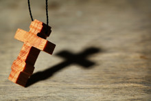 Wooden Cross With Deep Shadow On Wooden Background