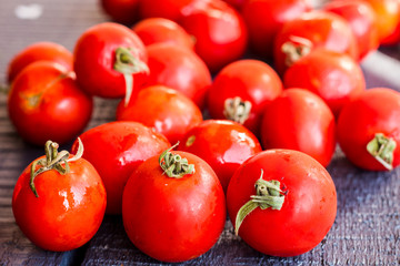 red juicy tomatoes cherry on dark wooden board