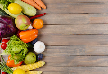 Fresh organic fruits and vegetables on wooden background