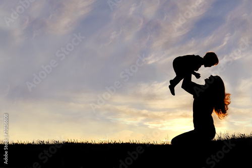 Fotografie, Obraz Silhouette of Happy Mother Playing Outside with Baby
