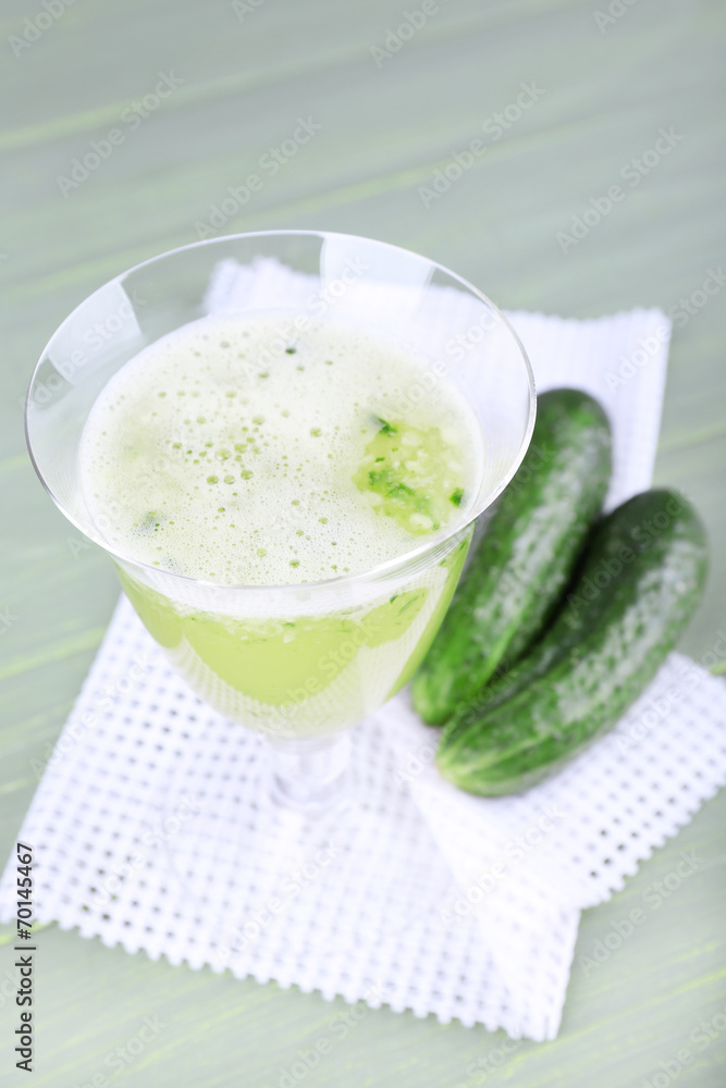 Cucumber cocktail on napkin on wooden background