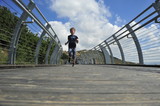 Fototapeta Młodzieżowe - Boy running on the mountain bridge