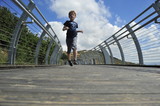 Fototapeta Młodzieżowe - Boy running on the bridge