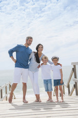 Wall Mural - happy family  standing on a wood pontoon in front of the sea in