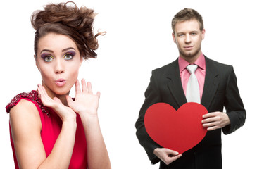 Poster - young surprised woman and handsome man holding red heart on whit