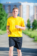 © mr.markin - Sporty man jogging in city street park. Outdoor fitness.