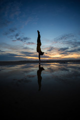 Canvas Print - girl doing handstand on beach in sunset