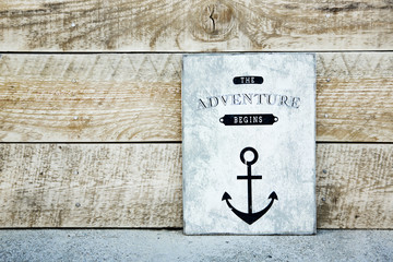 Wall Mural - motivational  vintage poster on the rustic wood ADVENTURE BEGINS