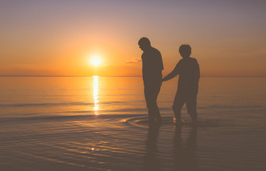 Senior couple walking at sunset