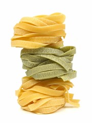 Stack of regular and spinach tagliatelle nest pasta