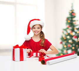 Canvas Print - smiling girl in santa helper hat with gift box