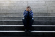 Leinwandbild Motiv Young homeless man sad crying in depression on ground street