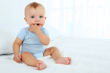 Cute Baby Boy On Bed In Room