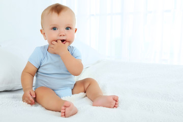 cute baby boy on bed in room
