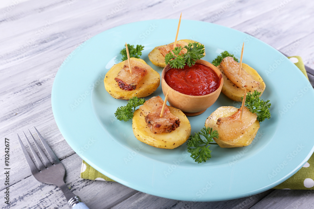 Baked potato with bacon on plate, on wooden background