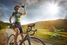 Cyclist is drinking water from the sport bottle