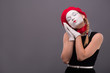 Waist-up portrait of young mime girl showing something