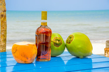 Coconuts And Liquor Bottle On Table By The Beach In Livingston