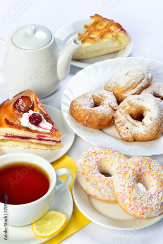 Obraz Dibond still life of setout table with baking pies, donuts, tee cup and