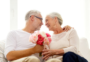 Wall Mural - happy senior couple with bunch of flowers at home