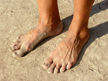 Dirty Male Feet On Dried Earth