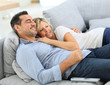 © goodluz - Middle-aged couple in sofa watching tv