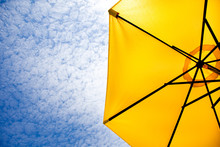 Yellow Sun Umbrella On A Blue Sky.