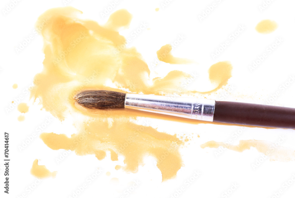 Brush and spilled paint isolated on white