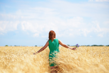 Young woman walking on wheat field