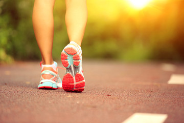 Wall Mural - young fitness woman legs running at forest trail