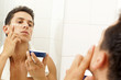 © cristovao31 - Young man applying facial cream at the bathroom