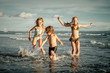 © altanaka - happy kids playing on beach in the day time