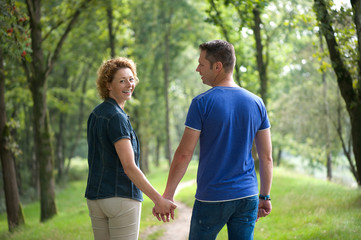 Wall Mural - Couple walking outdoors and holding hands