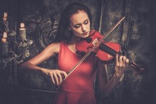 Young Woman In Red Dress Playing Violin In Mystic Interior