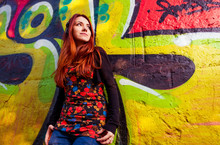 Young Redhead Woman At Colorful Graffiti Wall