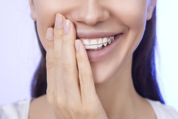 Portrait of Beautiful smiling girl covering her retainer for tee