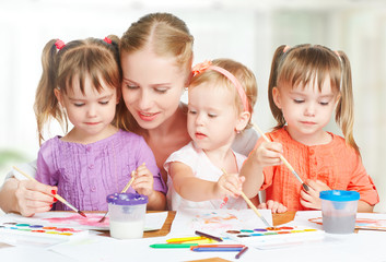 Wall Mural - children twin sisters draw paints with mother