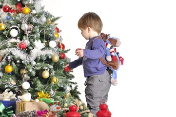 Сhild about a Christmas tree with two red lamps with backpack