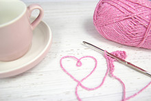 Pink Crochet Background With Yarn Heart And Coffee Cup