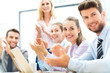 © pikselstock - Business team clapping in meeting