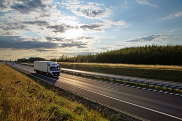 Shining sun over the highway, white truck on the road