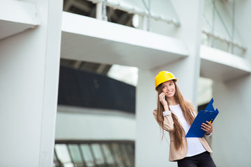 A pretty young woman working as architect on a construction site